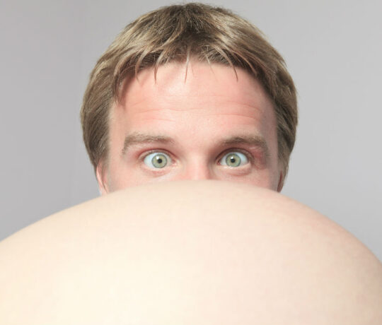 man looks at pregnant belly