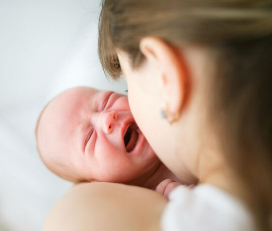 mom holding crying baby