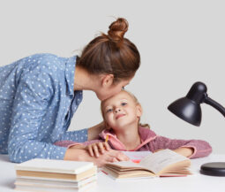 mom kisses little daughter on forehead