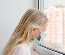 little girl with respiratory mask looking out