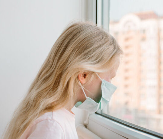 little girl with respiratory mask looking out