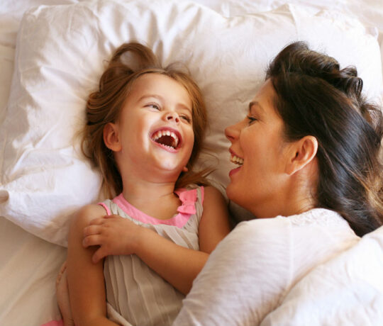 mom with little daughter laughing