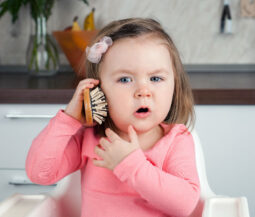 toddler playing brush phone
