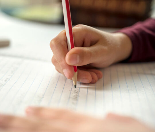 kid writes on a piece of paper