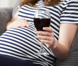 pregnant woman holding glass of red wine