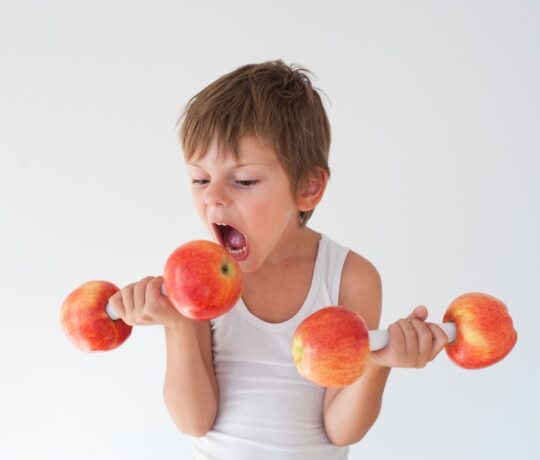 boy uses apples as weights