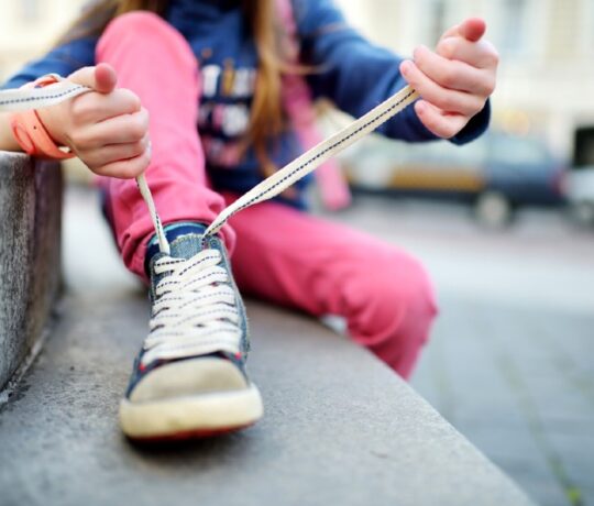 little girl ties shoel laces