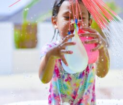 little girl play with water ballons