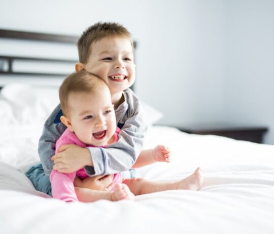 baby brother hugs his little baby sister