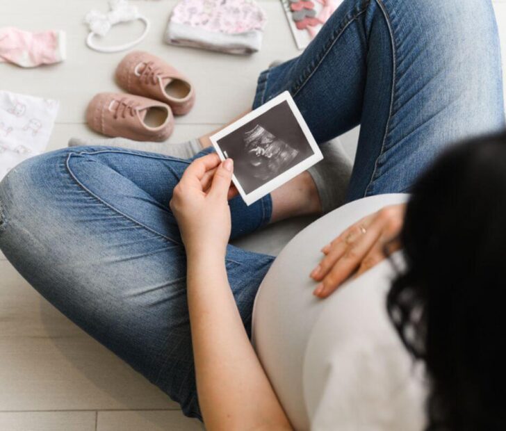 pregnant looking a photo of her baby inside her belly