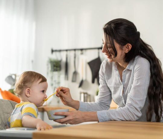 baby being fed by his mother