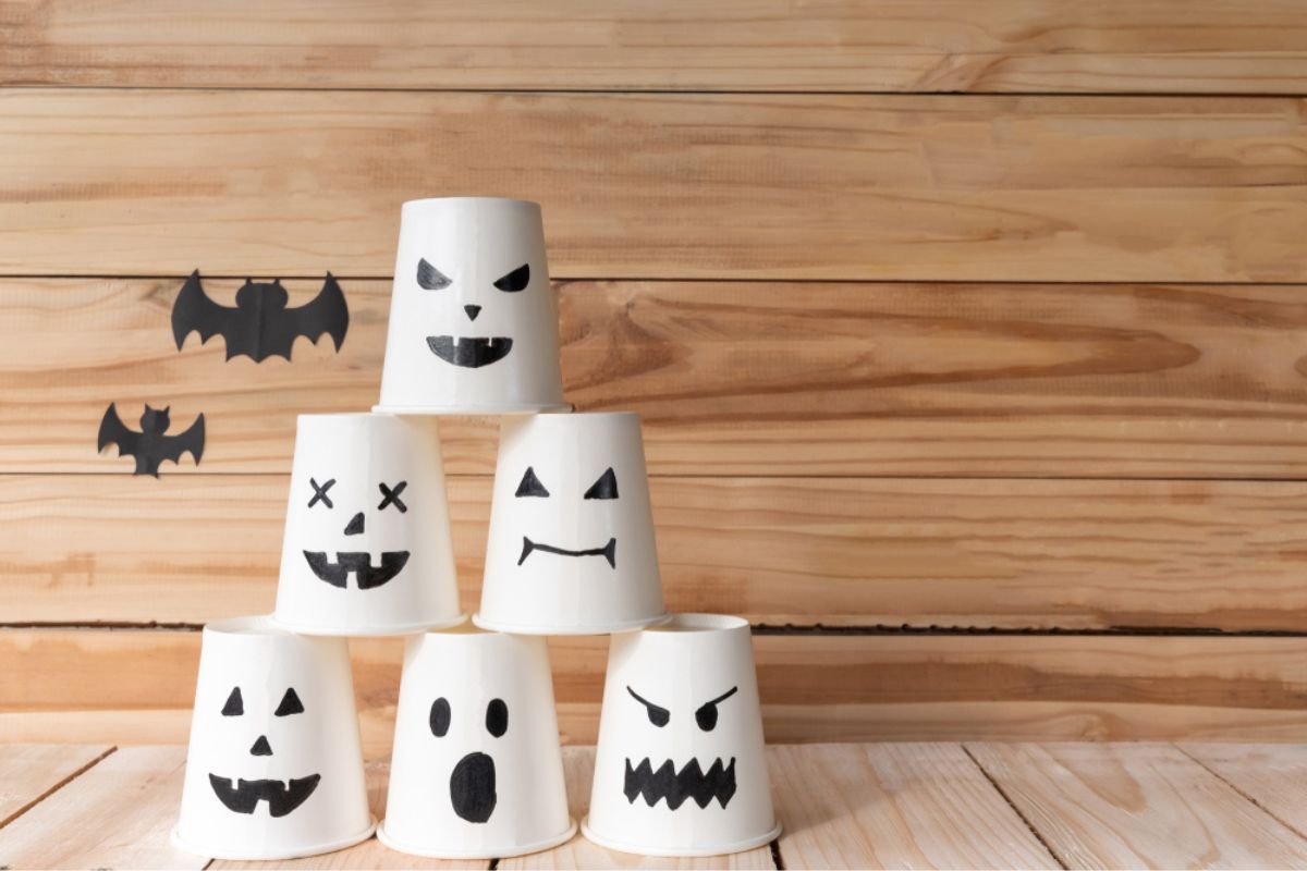 paper cup ghost on wooden wall background