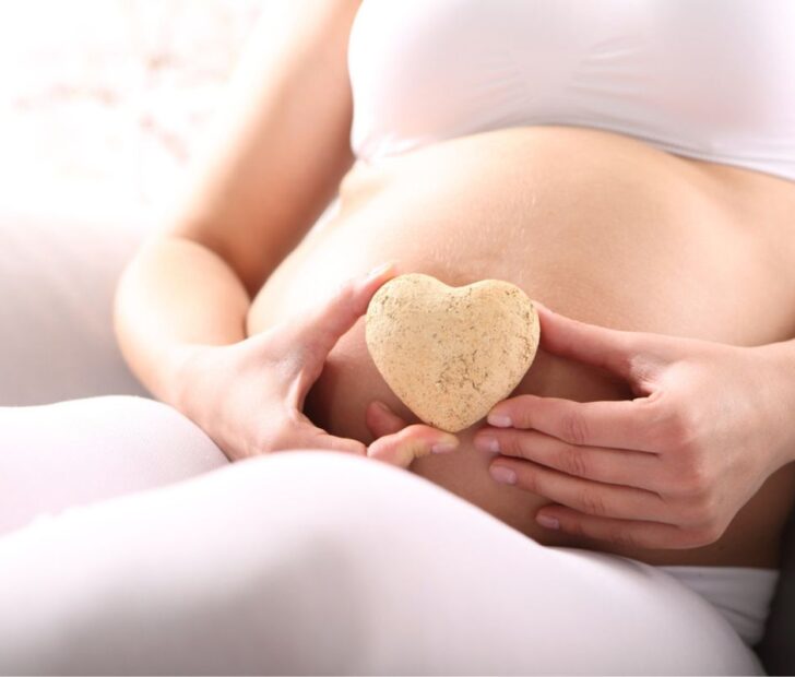 pregnant woman holding her belly