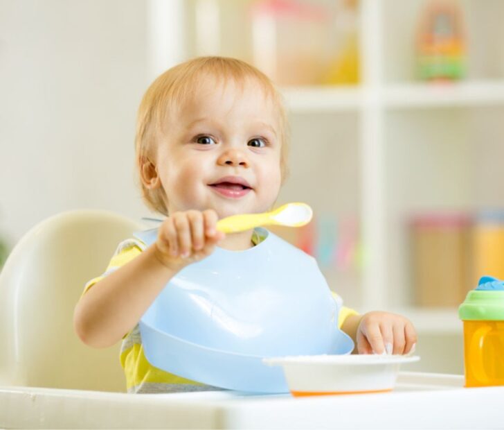 Infant eating with spoon