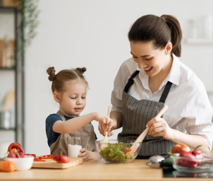 mom cooks healthy food with her children