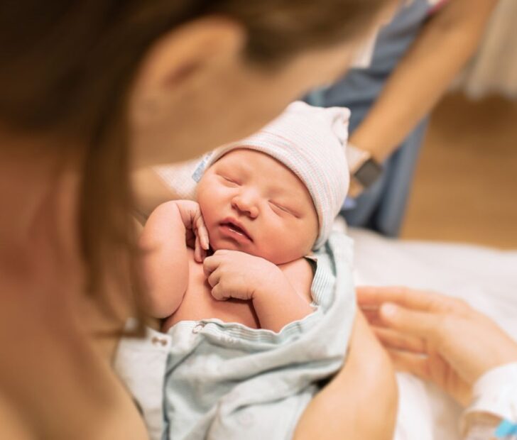 newborn baby hugging by his mom