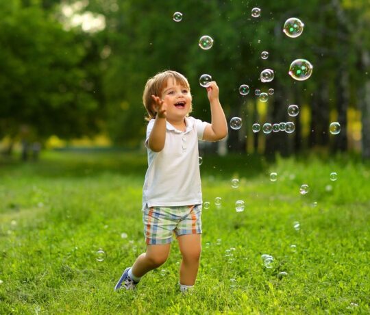 happy kid playing with bubles